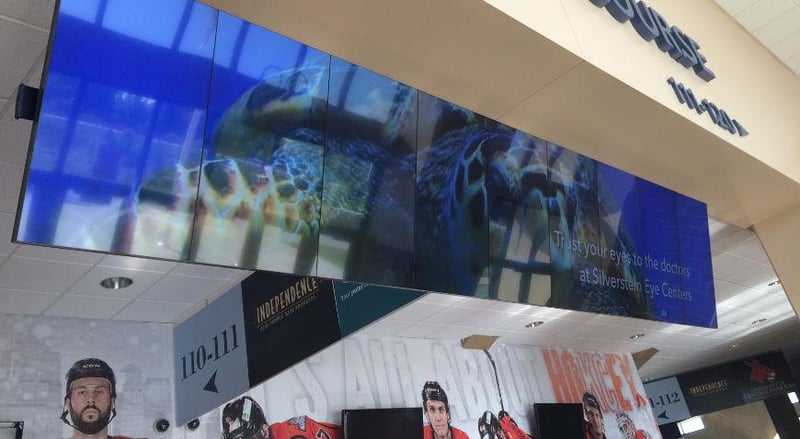 国家冰球联盟场馆内的悬挂式视频墙，展示了银泰眼科中心的广告。