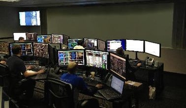 一个控制室，工人们在他们的工作站上工作。