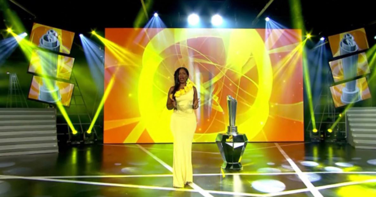 主持人在英超足球联赛颁奖典礼的舞台上，视频墙显示背景视觉效果