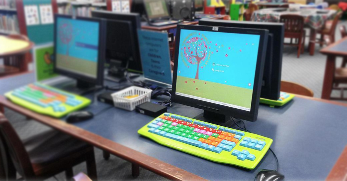 华沙社区公共图书馆的一张桌子，上面有使用Userful Desktop的电脑，还有彩色的键盘