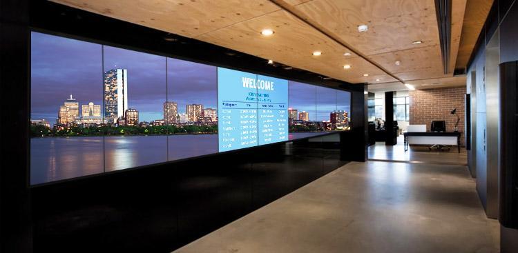 空旷的办公大厅，大型视频墙显示着欢迎横幅和城市天际线的照片