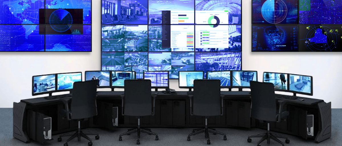 空旷的控制室，有4个工作站和3面视频墙，显示实时监控录像和数据仪表板