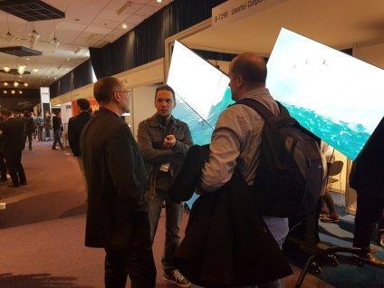 在阿姆斯特丹ISE 2018展会上，Userful员工和与会者在马赛克视频墙前聊天。