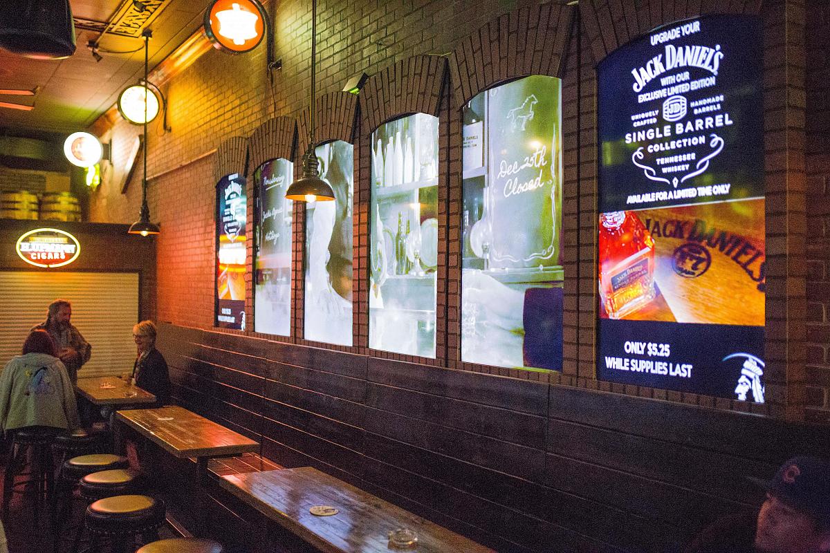 在Smokin' Joe's酒吧的窗口式视频墙，展示广告和视觉艺术。