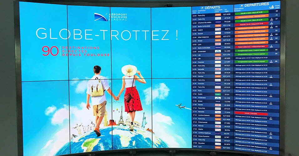 图卢兹-布拉格纳克机场的视频墙，显示广告和航班起飞时间